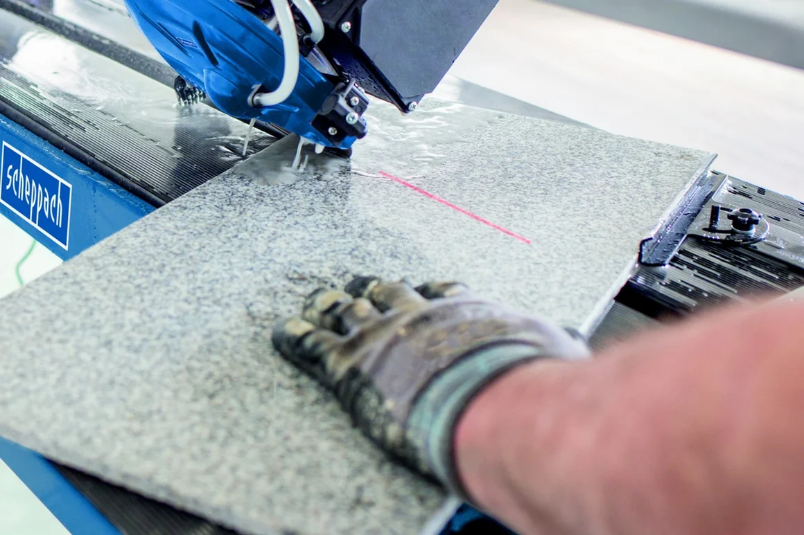 Person schneidet Fliese mit Säge